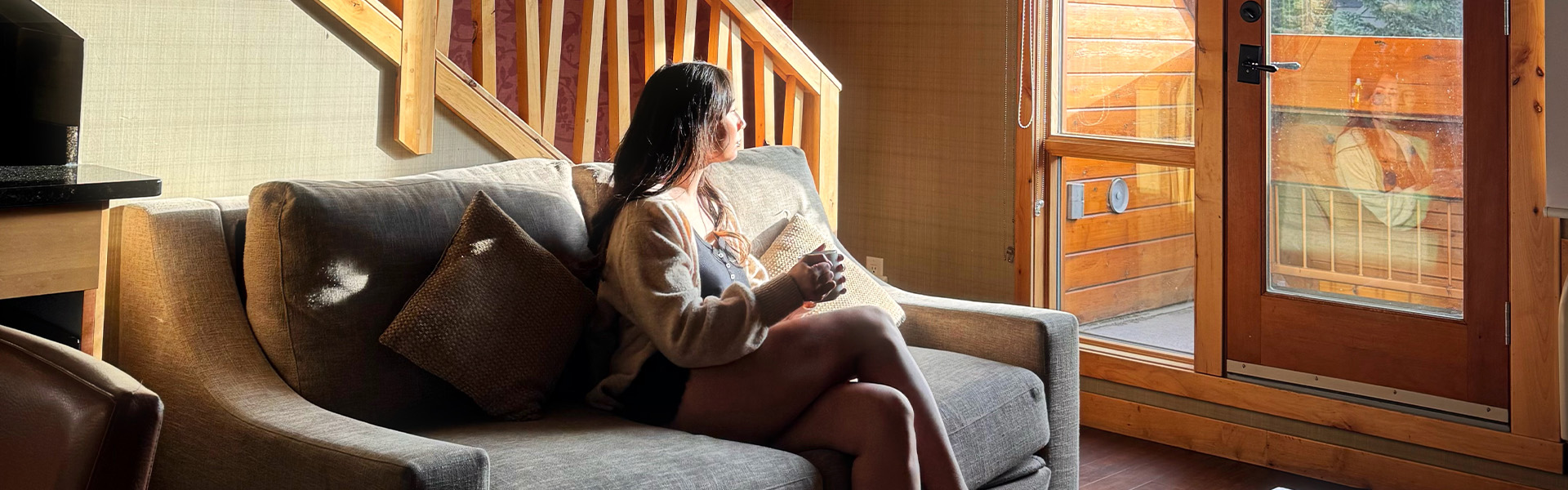 Guest relaxing on a couch in a room at Fox Hotel & Suites in Banff